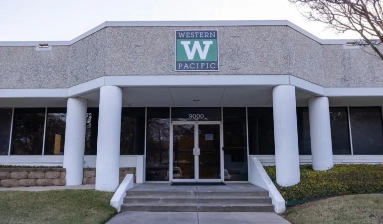 Entrance of a building with a Western Pacific logo above the doors and the address number 9000 displayed.